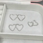 estojo com brincos de argola no formato de coração